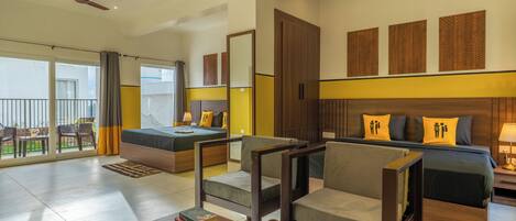 A modern hotel room with a balcony, a sofa bed, a wooden coffee table, and a TV.