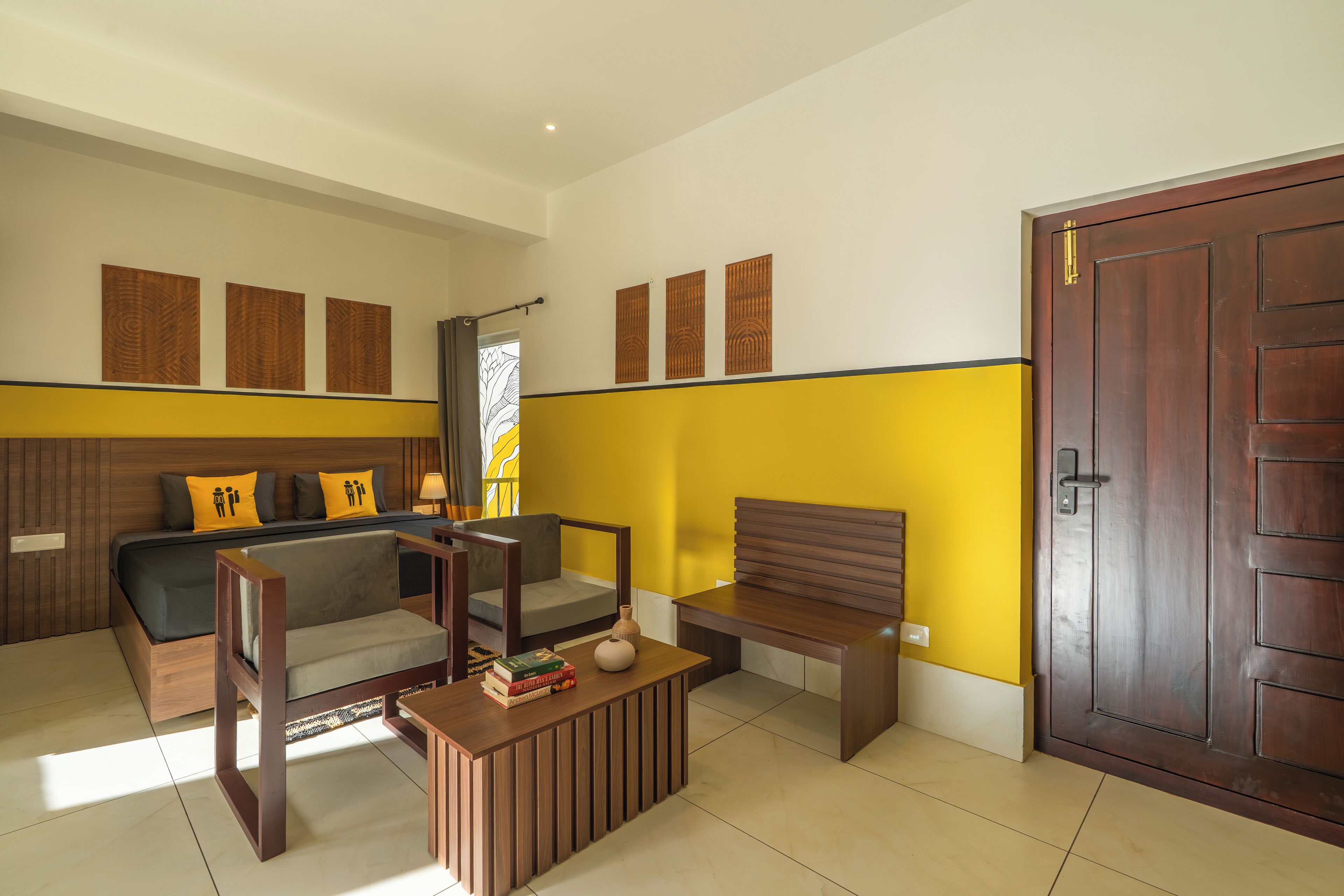 Una habitación de hotel moderna con una cama, un sofá, una mesa de centro de madera y una puerta.