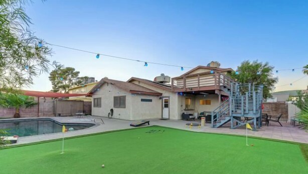 A house with a pool, a grassy lawn, and a play area with a slide. - Strip-Side Villa, 6 Beds, Pool, Mini Golf, Karaoke (Las Vegas)
