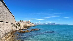 Un paese costiero con un muro di pietra e edifici che si affacciano sul mare.