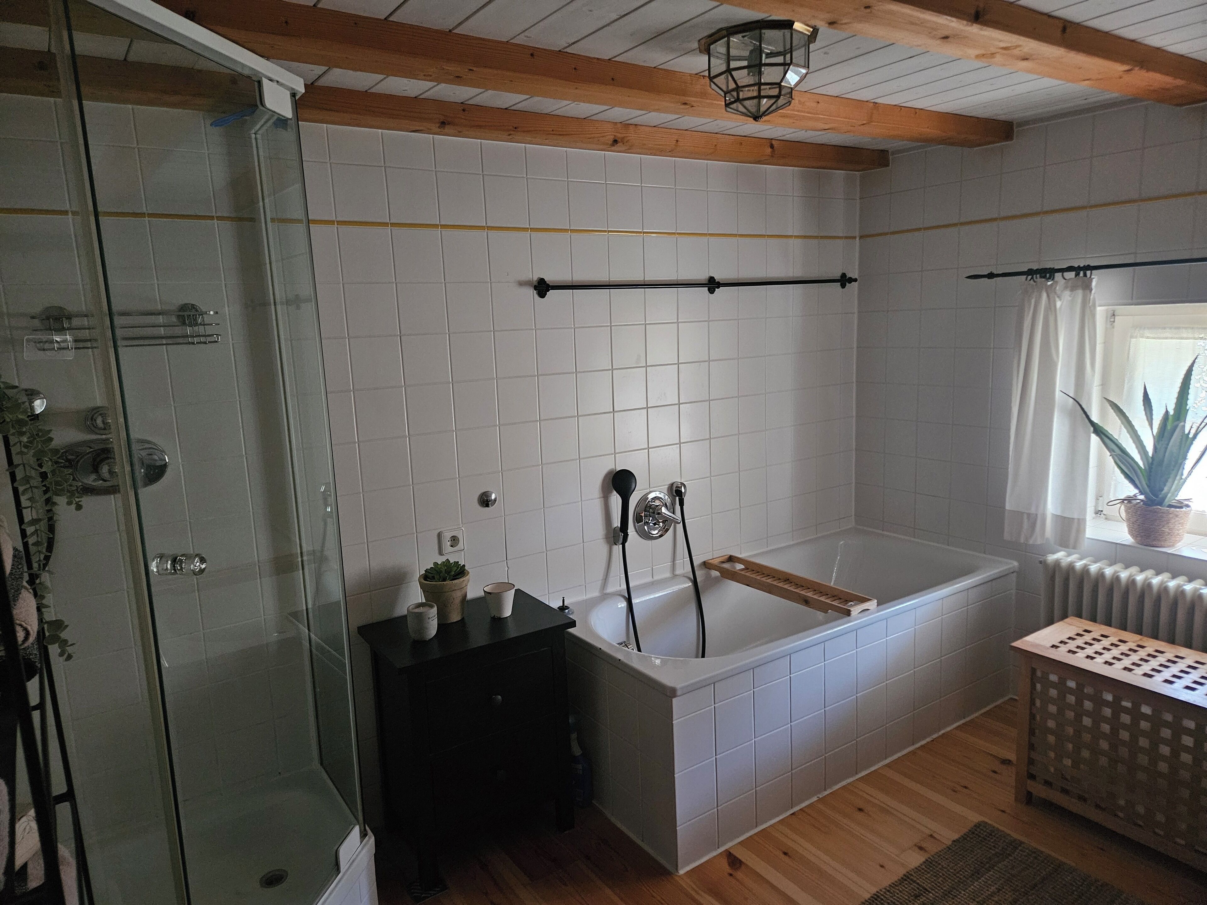 Une salle de bain moderne avec une douche à parois de verre, une baignoire sur pieds et un meuble-lavabo en bois.