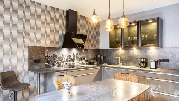 A modern kitchen with a marble countertop, pendant lighting, and a cityscape mural on the wall. - Apartment 'Marisa's Sauerland Dream' with Shared Terrace, Garden & Wi-Fi (Brilon)