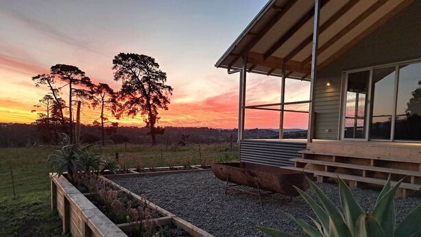A modern house with a large glass window overlooking a garden. - Grasmere Lodge with Garden (Gruyere)