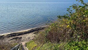 A coastal view with a sandy beach and a wooden walkway leading to the water. - Awesome home in Egernsund with house sea view (Egernsund)
