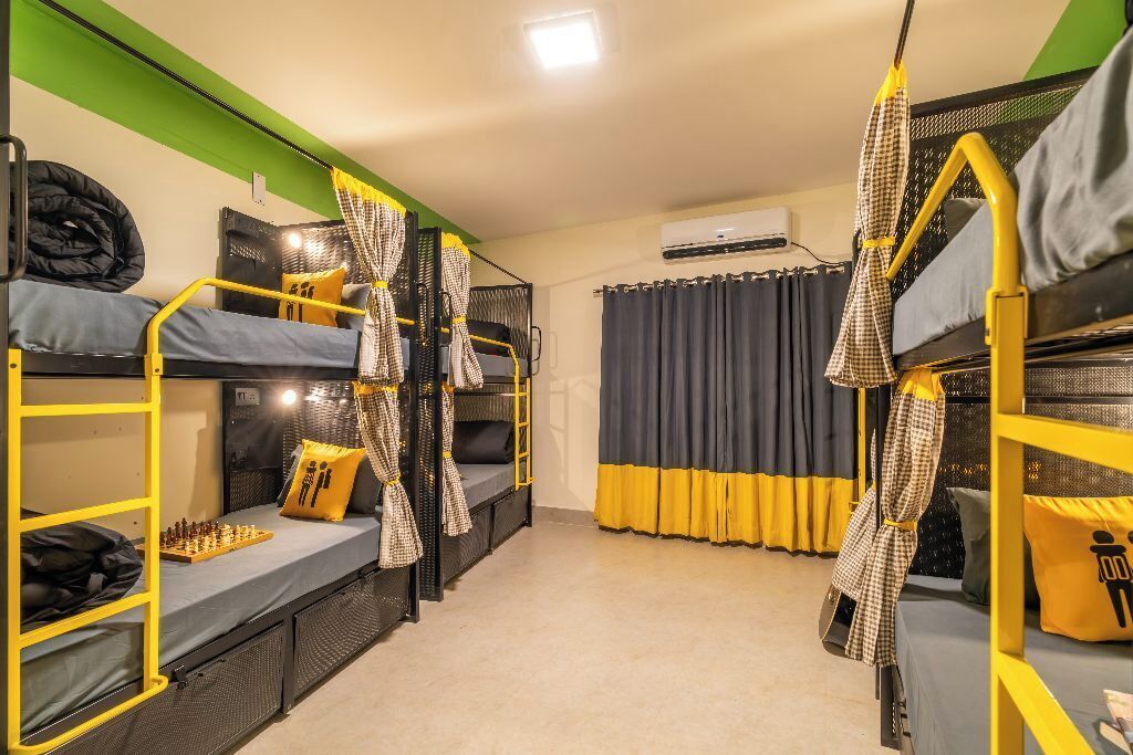 A dormitory room with bunk beds, a chessboard, and curtains.