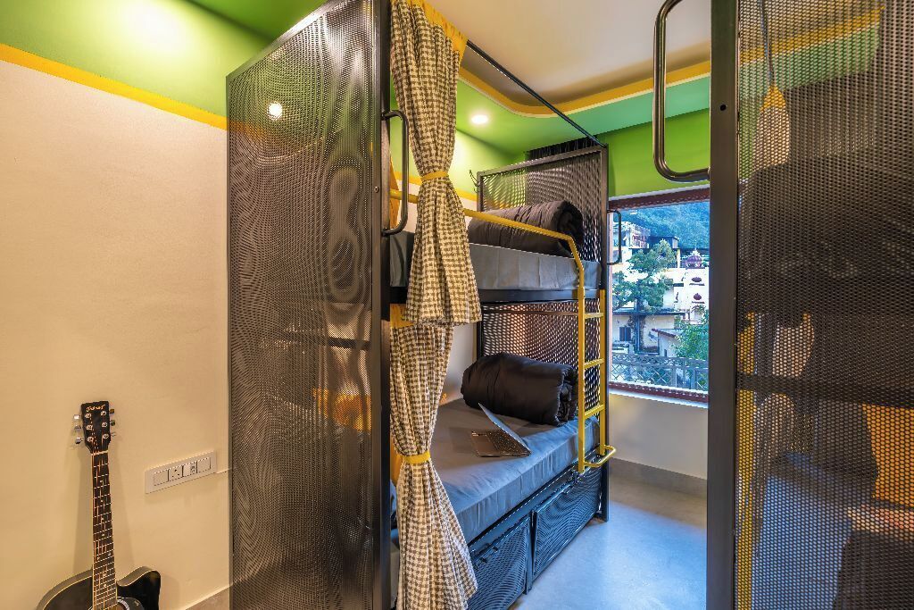 A bunk bed room with a view of buildings outside.