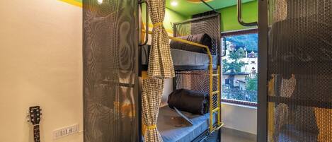 A bunk bed room with a view of buildings outside.