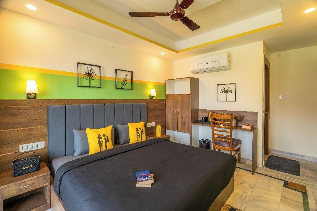 A hotel room with a bed, bedside table, lamp, and a wardrobe.
