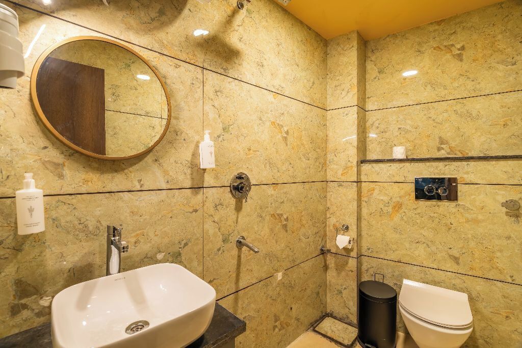 Un baño con lavamanos, espejo, inodoro y ducha.
