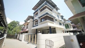 A multi-story residential building with a flat roof, large windows, and a gated entrance. - Vallimony Luxury Stays-Padmanabha Temple (Thiruvananthapuram)