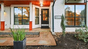 Una casa moderna con facciata bianca, una porta d'ingresso nera e il numero 8922.