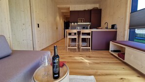 Een gezellig houten interieur met een eethoek, keuken en zithoek.