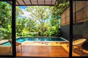 A wooden deck with a pool, surrounded by lush greenery and a pergola. - New authentic Jungle Gem (Nosara)
