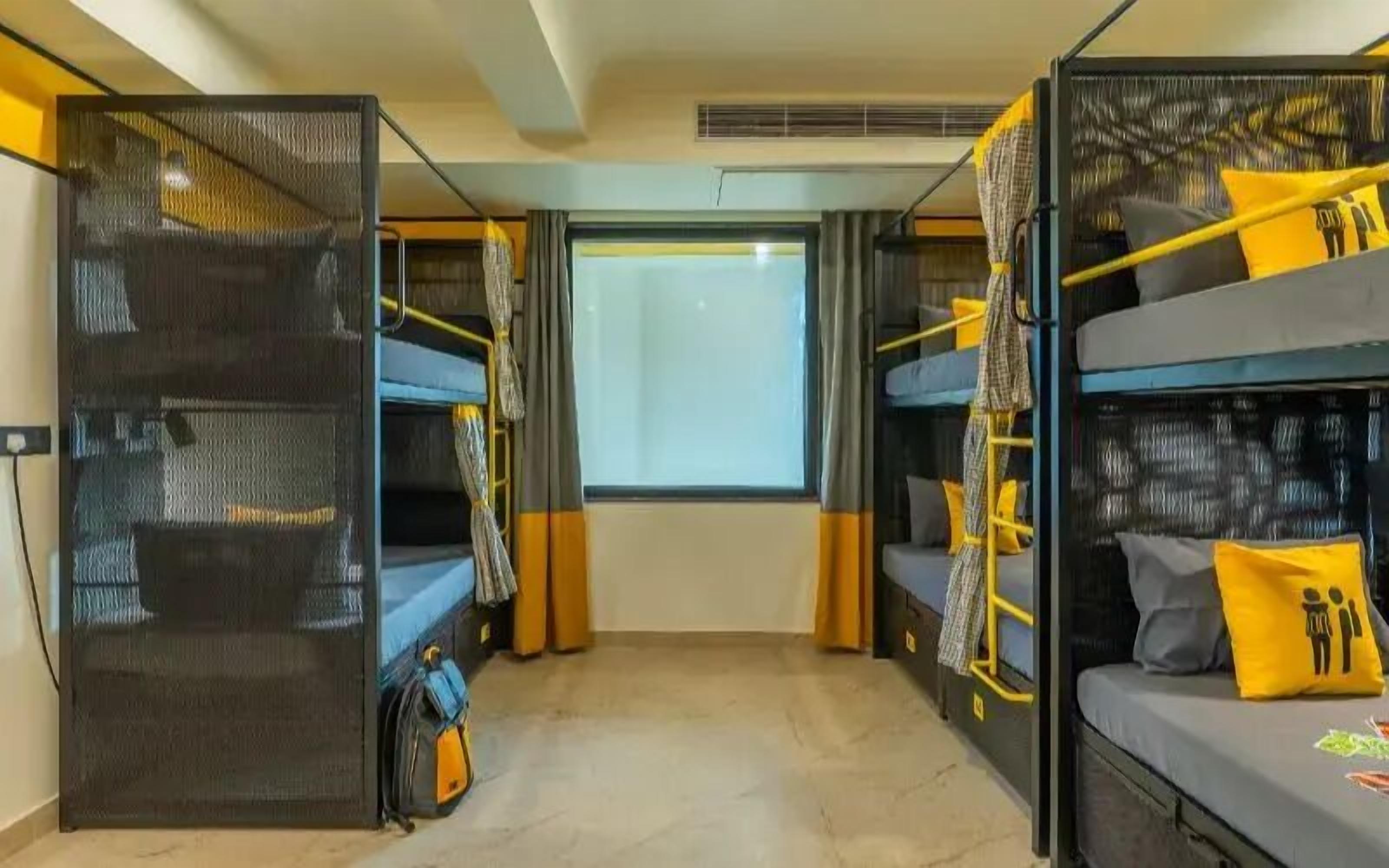 Habitación pequeña con literas, una ventana y una puerta.