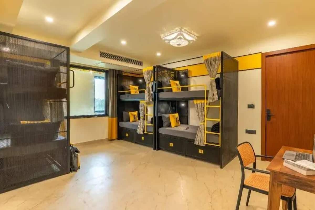 Una habitación con literas, un escritorio y una silla.