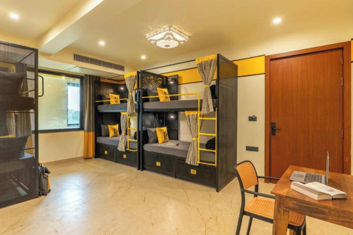 A room with bunk beds, a desk, and a chair.