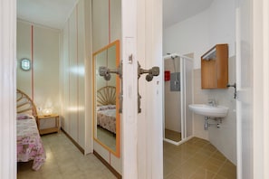 Une chambre à coucher avec un lit, une table de chevet et un miroir.