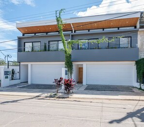 A modern two-story house with a flat roof, large windows, and a garage. - Entire home in Tamarindo, Costa Rica - 10 guests4 bedrooms6 beds3.5 baths (Tamarindo)