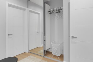 A modern room with white doors, a mirror, and a clothing rack. - 3BR HOUSE FULLY RENOVATED 2025: FENCED YARD/PATIO & CARPORT in NOHO ARTS DISTRICT p85 (Los Angeles)