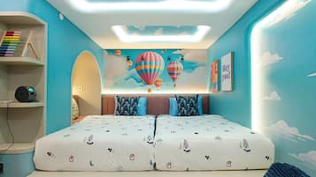 Un dormitorio con cama, almohadas, una estantería con libros y un mural de un globo aerostático en la pared.