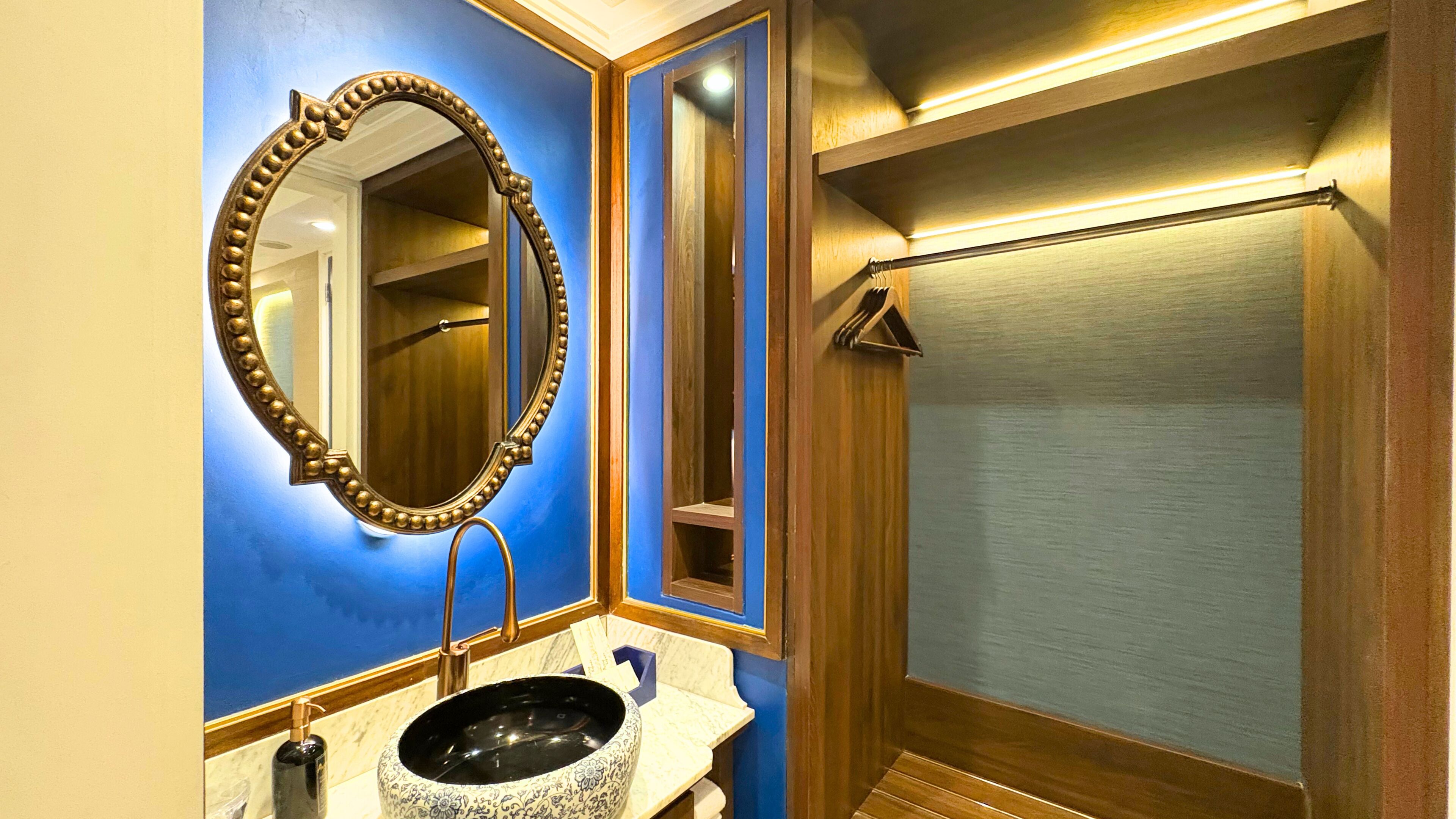 A bathroom with a large mirror, a sink with a patterned basin, and a shower area.