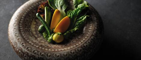 A decorative plate with a patterned design, containing various vegetables.
