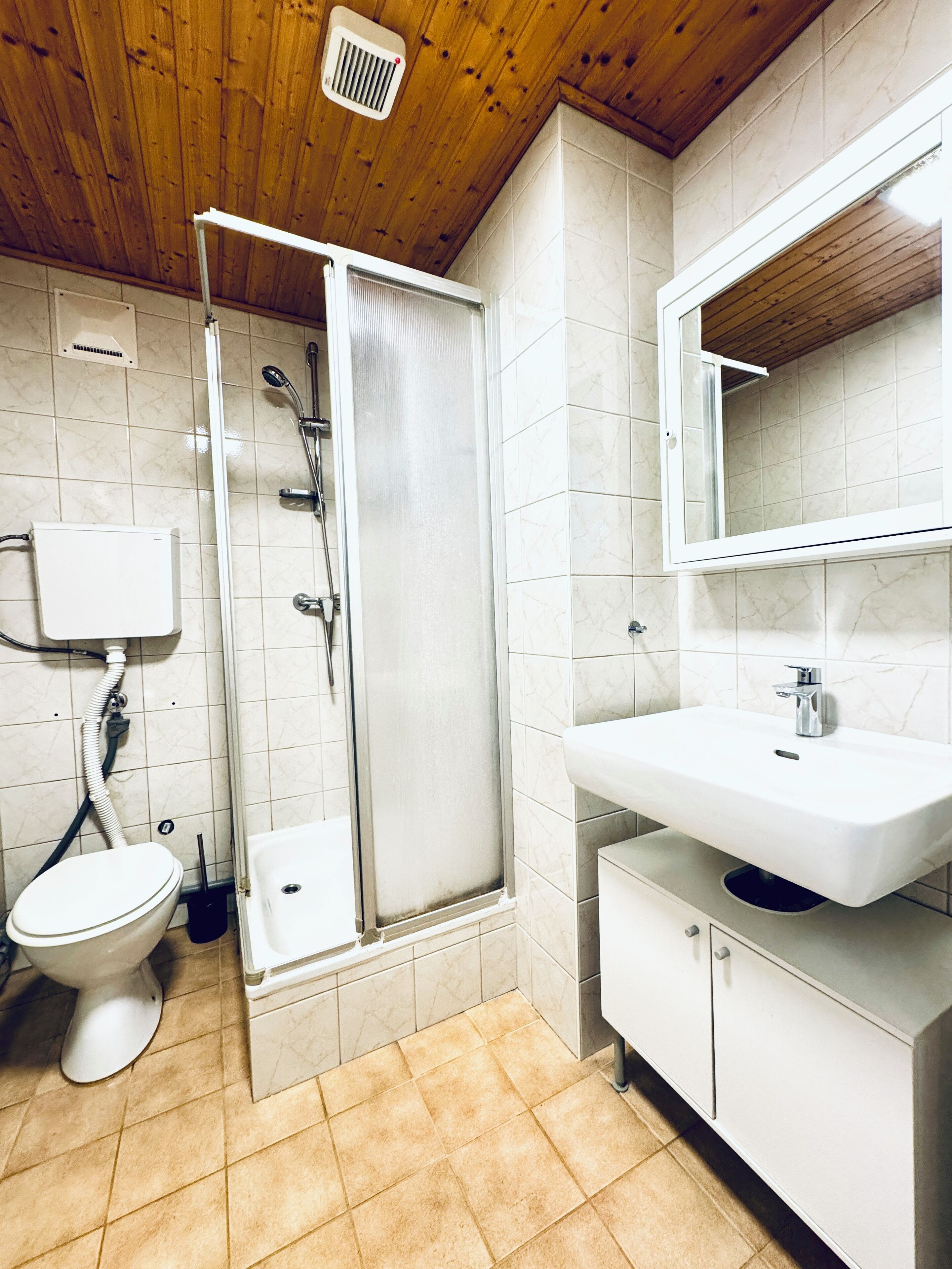 Une salle de bain avec une douche, des toilettes et un lavabo.