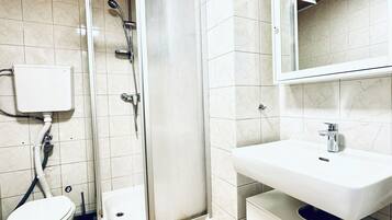 Une salle de bain avec une douche, des toilettes et un lavabo.