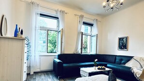 Une chambre à coucher comprenant un lit, un canapé, une table basse et un lustre.