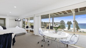 A modern bedroom with a large window, a bed, a desk, and a chair. - Amazing views and short walk to beach (AVOCA BEACH)