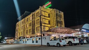 Un hotel con una fachada grande e iluminada y un área de entrada cubierta.