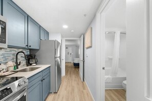 Eine moderne Küche mit blauen Schränken, einem Edelstahlkühlschrank und einem eingebauten Backofen.