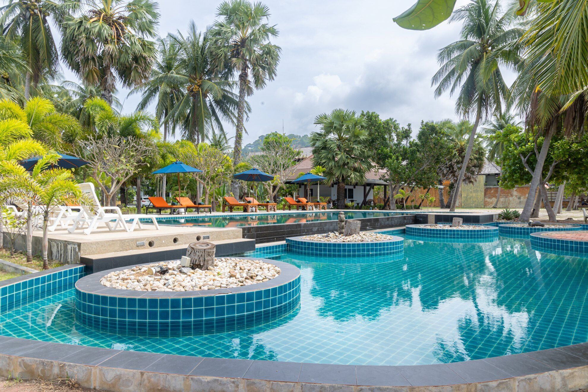 Una piscina al aire libre, sombrillas, tumbonas