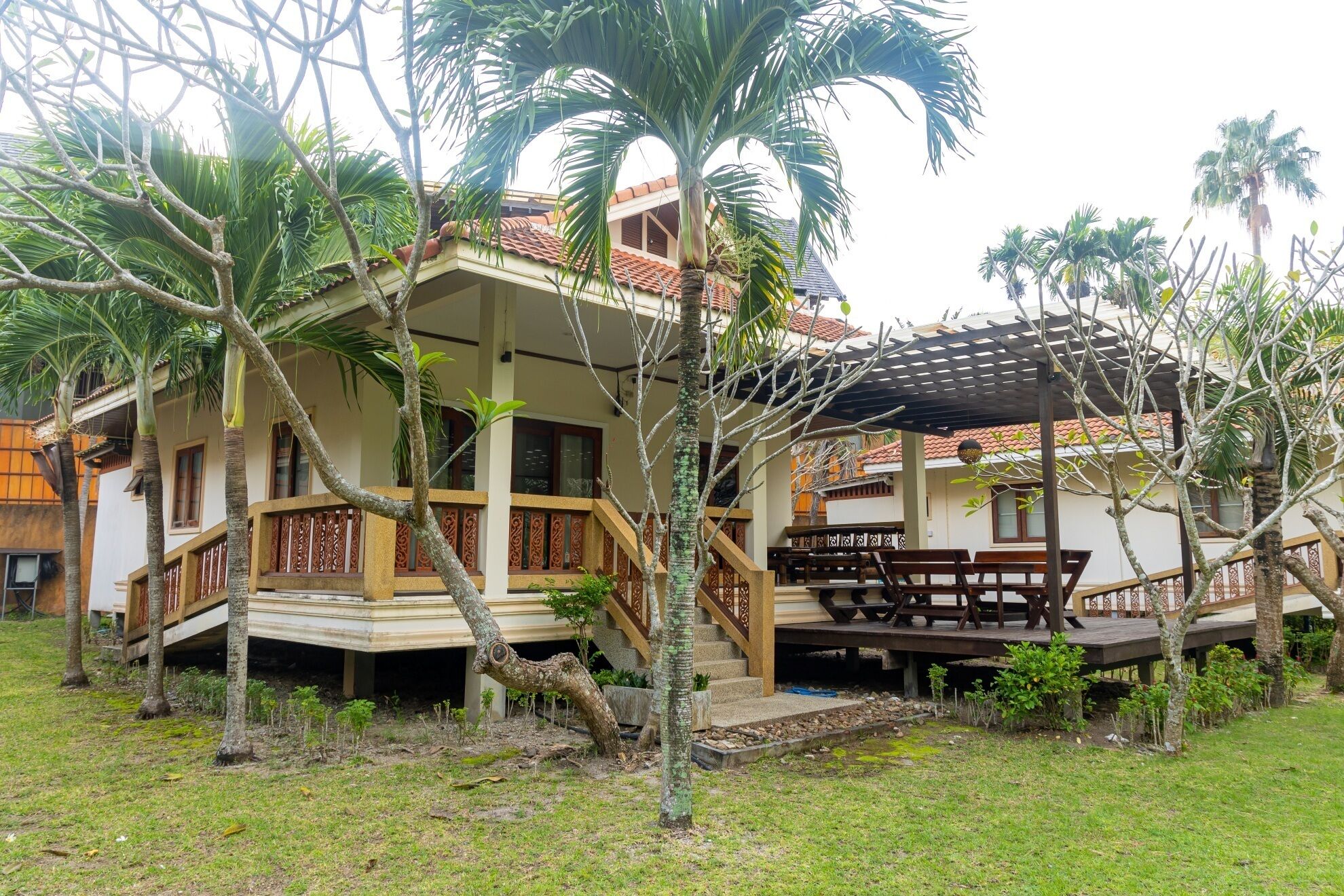 A two-story building with a balcony and a covered outdoor seating area.