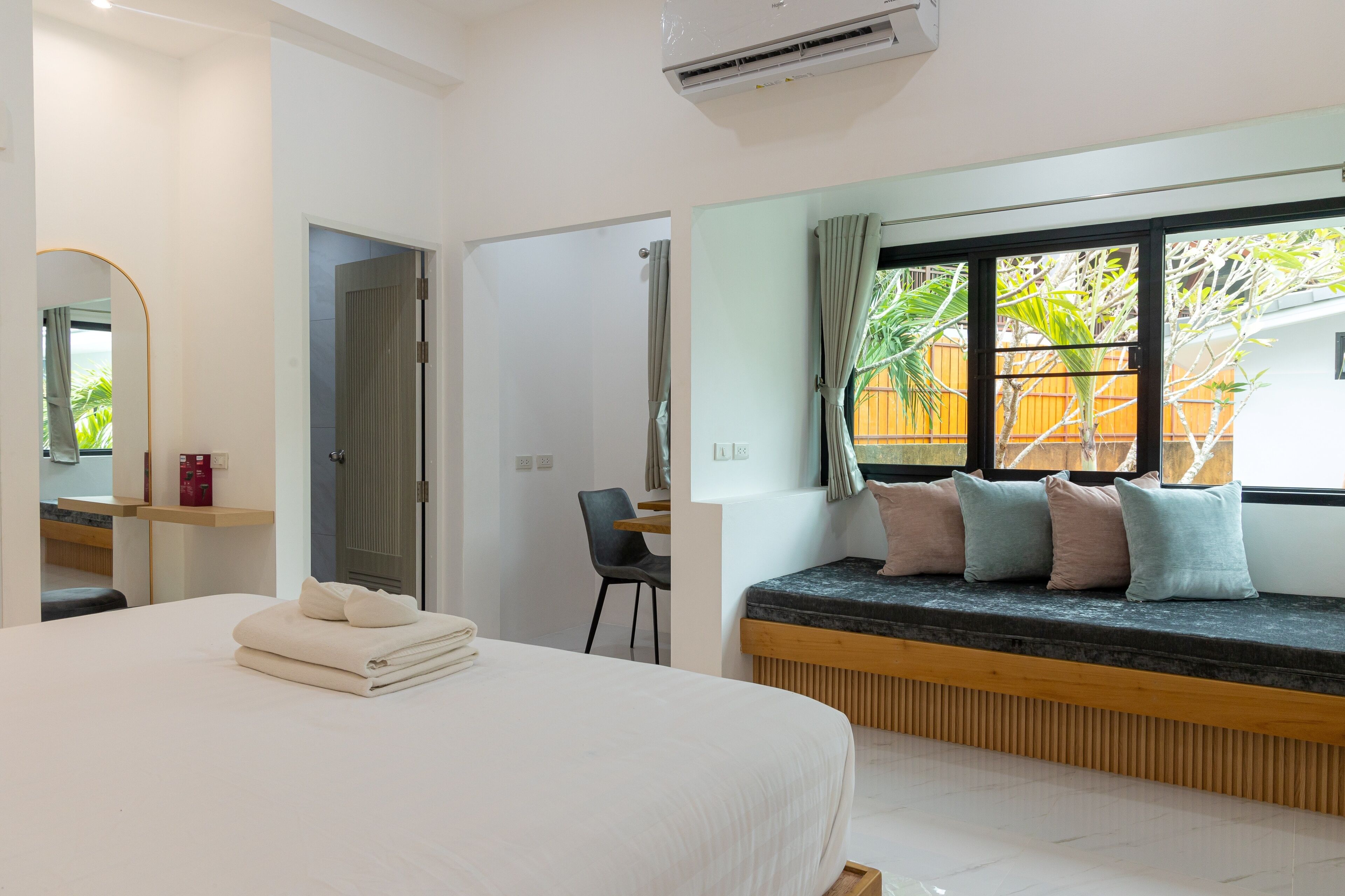 Ett modernt hotellrum med en stor säng, ett skrivbord och ett fönster med utsikt över omgivningarna.