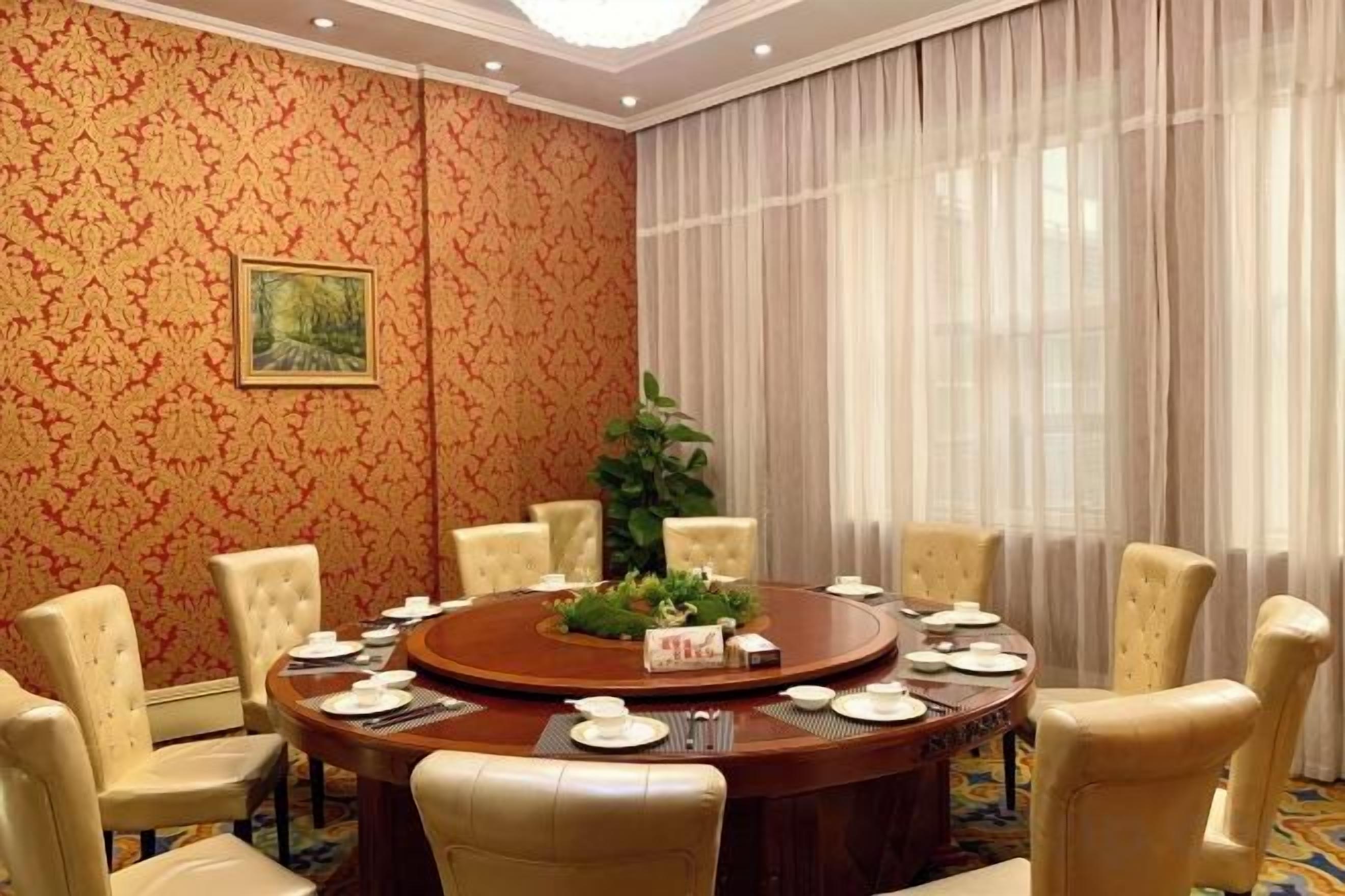 Une salle de conférence avec une table ronde, des chaises et une plante.