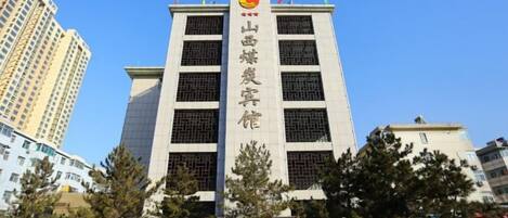 A multi-story building with a prominent vertical sign.