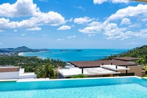 Piscina com vista para o oceano e uma costa distante.
