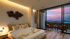 A bedroom with a large bed, a view of the cityscape, and a balcony with chairs. - 【Villa lamer】 Deluxe Sea View Villa (Koh Samui)