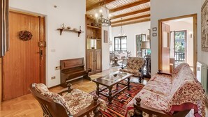 A spacious living room with a wooden ceiling, a sofa, a coffee table, and a fireplace. - Appartamento Apapa House With Balconies (Cesana Torinese)
