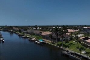 A residential area with houses along a waterway, docks, and palm trees. - Villa Pearl (Cape Coral)