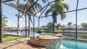 A hot tub with a view of a lake and palm trees.