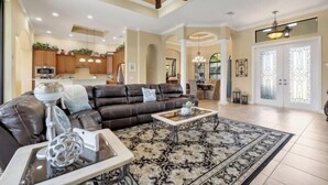 A spacious living room with a leather sofa, a coffee table, and a patterned rug.