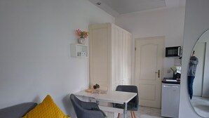 A compact living space with a sofa, a dining table, and a kitchenette. - Holiday Home 'Stahlberg' with Private Terrace, Balcony and Wi-Fi (Potsdam)