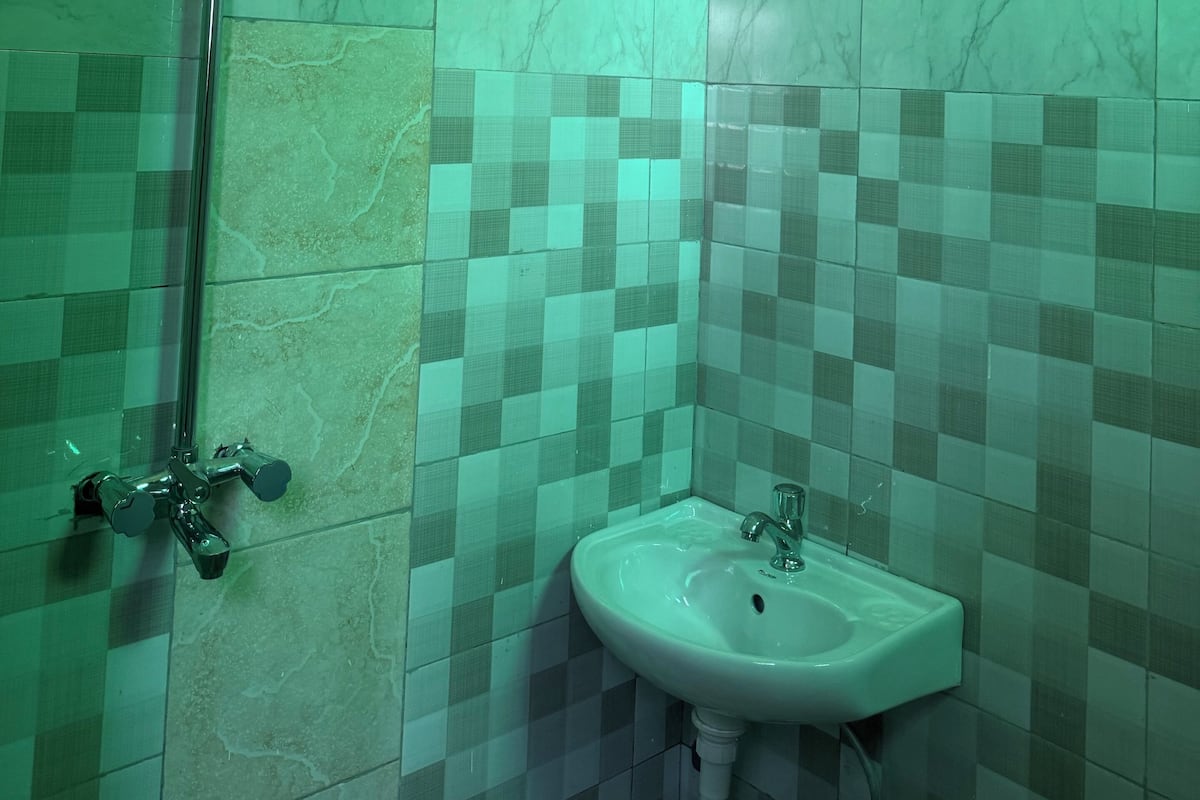 A bathroom with a shower, a sink, and tiled walls.