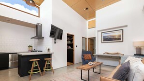 A compact living space with a kitchenette, a sofa, a coffee table, and a TV. - 'The Foundry' Modern Industrial Home w/Courtyard & Fireplace, Adelaide CBD (Adelaide)