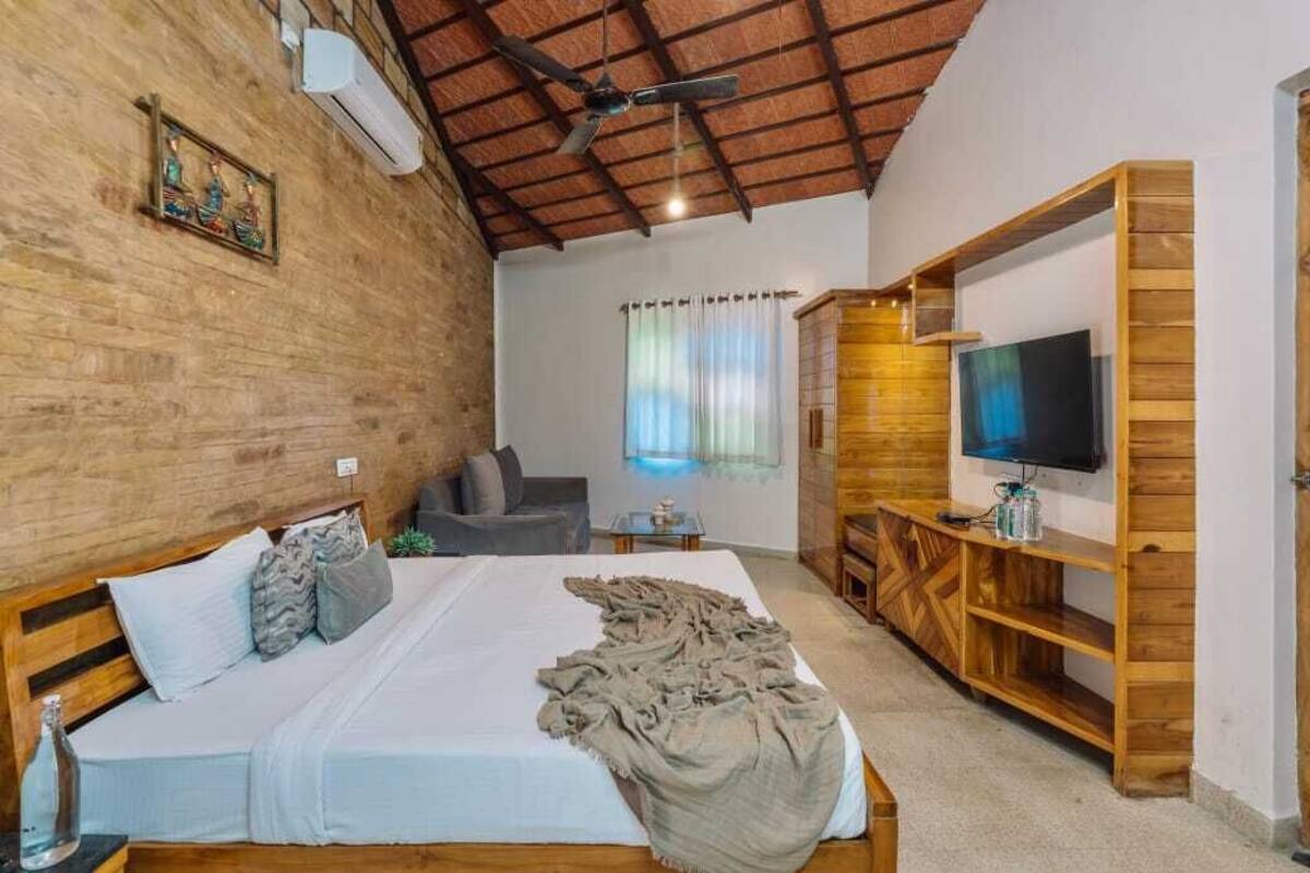 Ein Schlafzimmer mit einem hölzernen Bett, einem Fernseher auf einem Holzschrank und einem Deckenventilator.