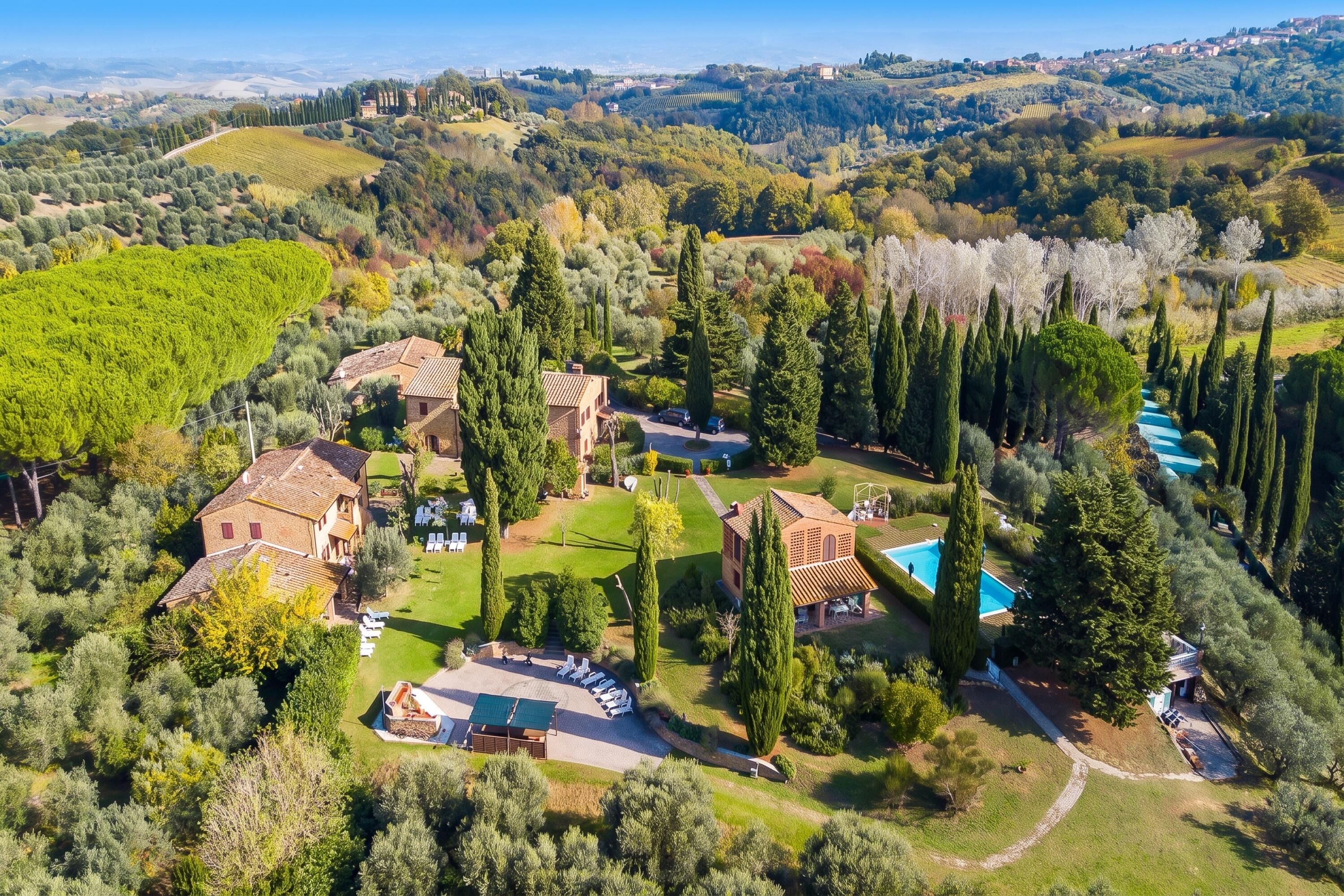 A large estate with multiple buildings, a swimming pool, and extensive gardens.