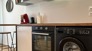 A compact kitchen with a built-in oven, microwave, and washing machine. - Modern apartment - Railway station - City center (Le Mans)