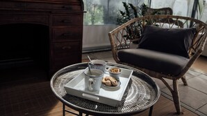 A cozy room with a wicker chair, a tray with a mug, and a tray with cookies. - Quinta das Essencias (Penafiel)